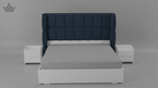 Gray bed with navy headboard and white nightstands on a gray background