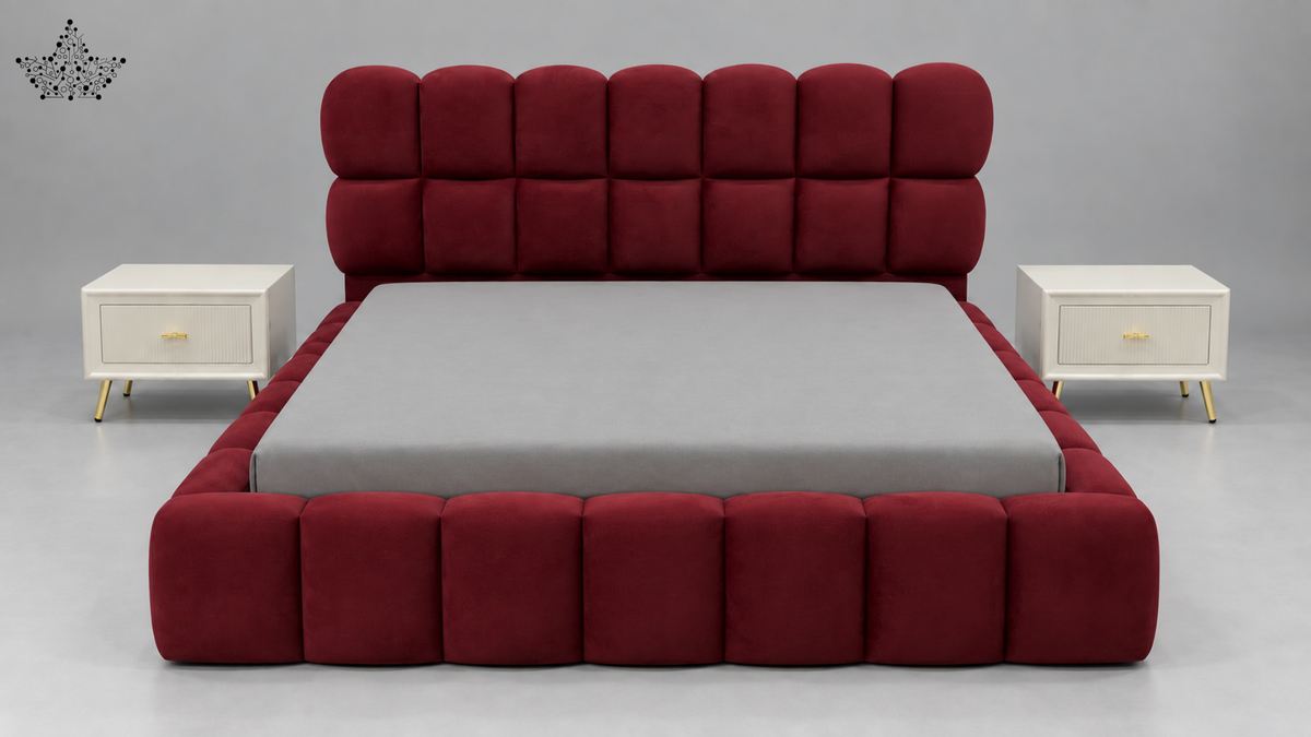 A modern platform bed with a high, segmented tufted headboard and matching footboard in deep burgundy velvet, flanked by two white nightstands with gold legs on a gray studio background.
