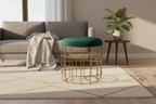 Green cushioned stool with gold wire frame on a white background