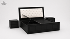 Black bed with tufted headboard and matching nightstands on a white background