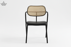 Chair with black frame and woven backrest on a white background