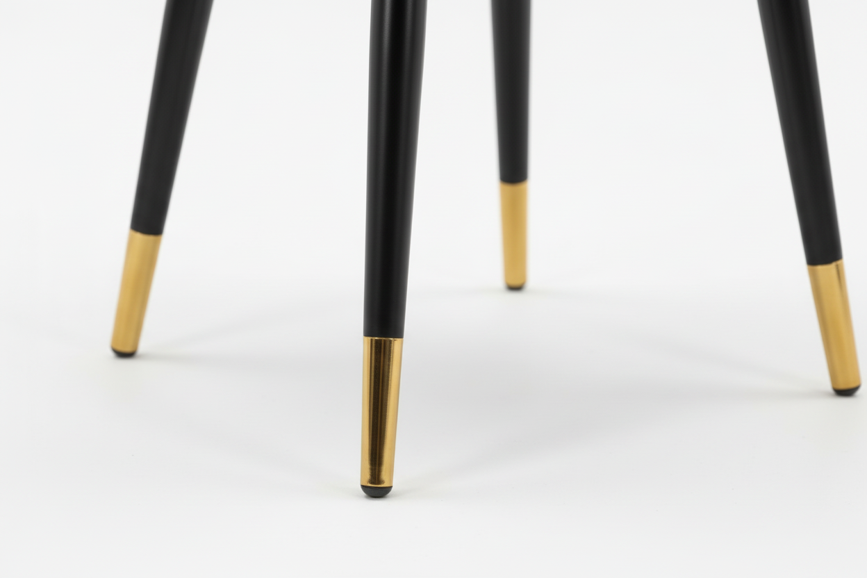Gray upholstered chair with black legs and gold feet on a white background