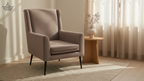 Beige armchair in a room with curtains and a small table.
