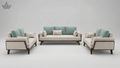 Modern sofa set with light gray and teal cushions on a plain background