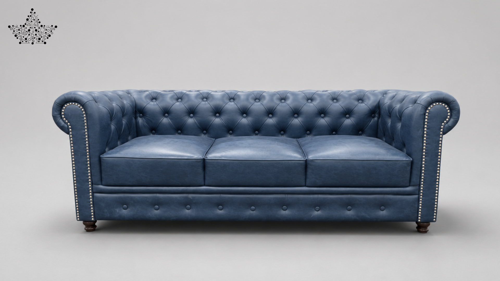 A classic Chesterfield-style three-seater sofa upholstered in blue leather with tufted button detailing, rolled arms, nailhead trim, and dark wooden legs, shown against a neutral gray studio background.