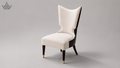 A modern wingback armchair with cream-colored tufted upholstery, dark brown side panels and legs, and gold-tone metal tips, shown against a neutral gray studio background.