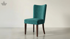 Teal upholstered chair with wooden legs on a plain background