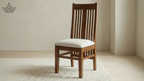Wooden chair with a white cushion on a beige floor and wall.