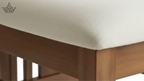 Close-up of a wooden chair with a white cushioned seat