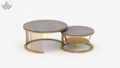 Set of two round coffee tables with gold metal frames and concrete tops on a white background