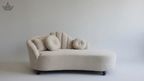 Beige sofa with circular cushions on a plain background
