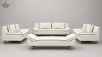 A 5-piece modern living room furniture set in off-white leather with black piping and light wood legs, including a sofa, two armchairs, and a coffee table, shown against a neutral gray background.